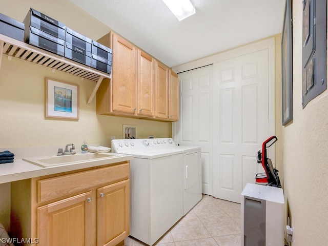 clothes washing area featuring cabinets, sink, washing machine and dryer, and light tile patterned flooring