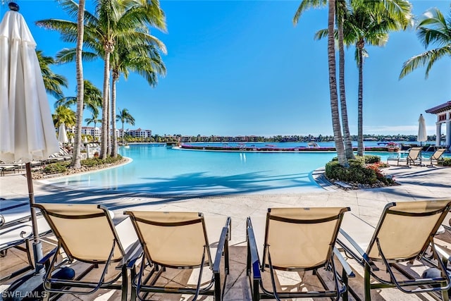 view of pool with a patio and a water view