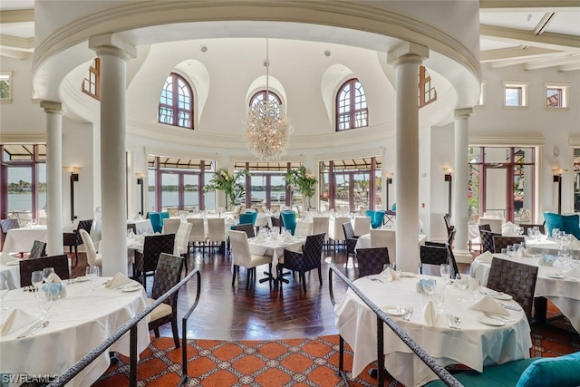 dining area featuring beam ceiling, a chandelier, high vaulted ceiling, and plenty of natural light