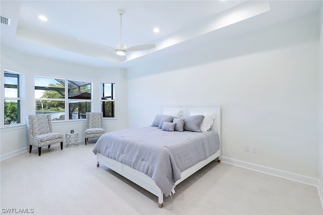 bedroom with a raised ceiling and ceiling fan