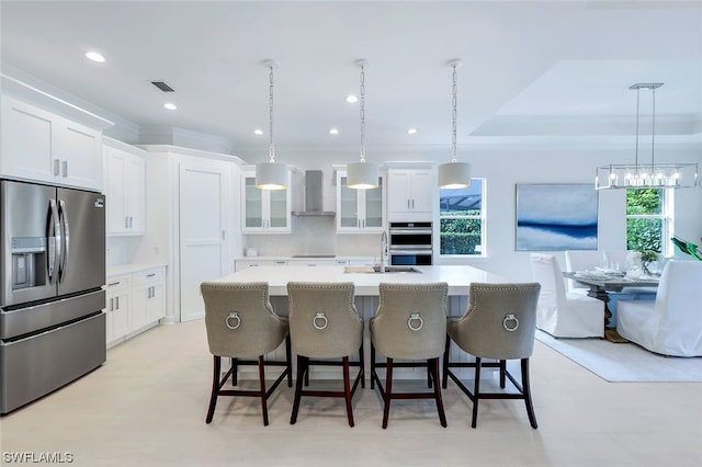 kitchen featuring backsplash, appliances with stainless steel finishes, wall chimney exhaust hood, and white cabinetry