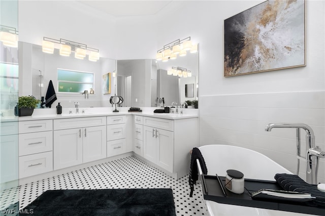 bathroom featuring double vanity, a freestanding bath, a sink, and wainscoting