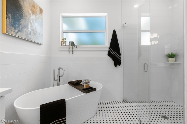 full bathroom featuring a stall shower, a soaking tub, wainscoting, and tile walls