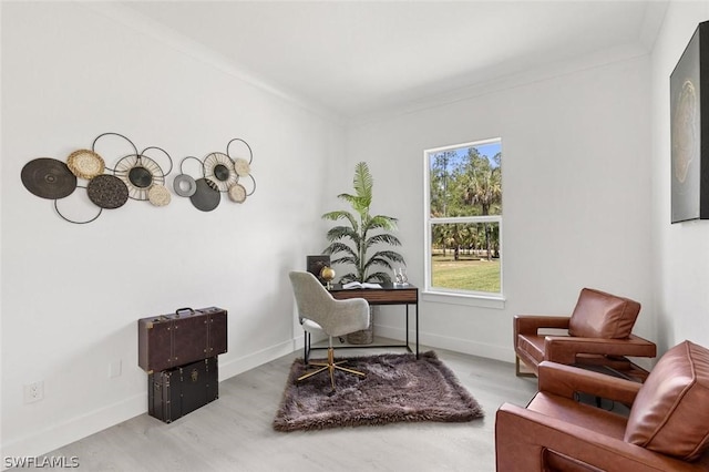 interior space featuring baseboards, ornamental molding, and wood finished floors