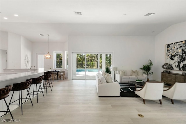 living area featuring light wood-style flooring, visible vents, and recessed lighting