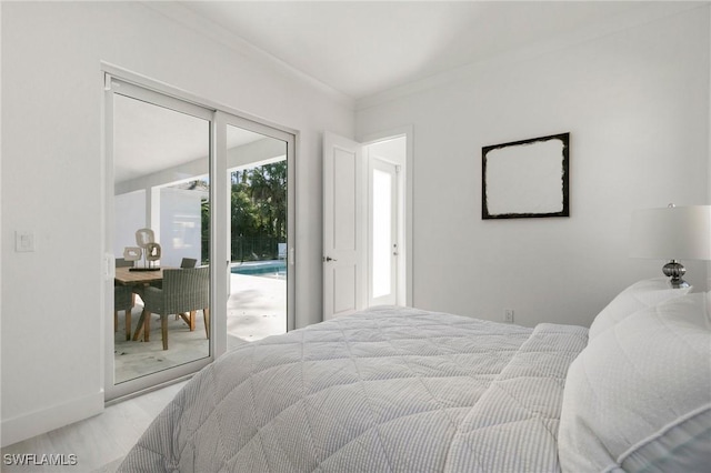 bedroom featuring access to exterior, baseboards, ornamental molding, and wood finished floors