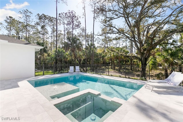 view of pool with a patio, fence, and a pool with connected hot tub