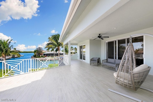 view of patio featuring a water view, outdoor lounge area, and ceiling fan