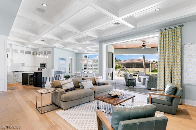 living room featuring coffered ceiling, beam ceiling, light hardwood / wood-style floors, and ceiling fan