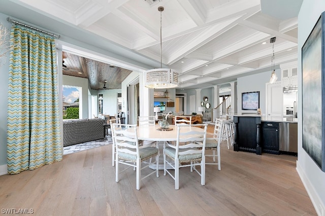 dining space featuring coffered ceiling, light wood-type flooring, and beam ceiling