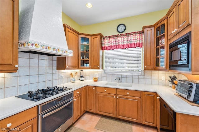 kitchen featuring stainless steel oven, tasteful backsplash, custom range hood, and black microwave