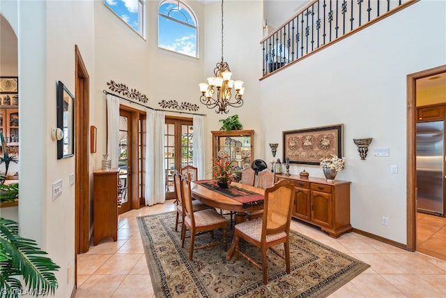 dining space featuring a notable chandelier, a high ceiling, light tile floors, and french doors