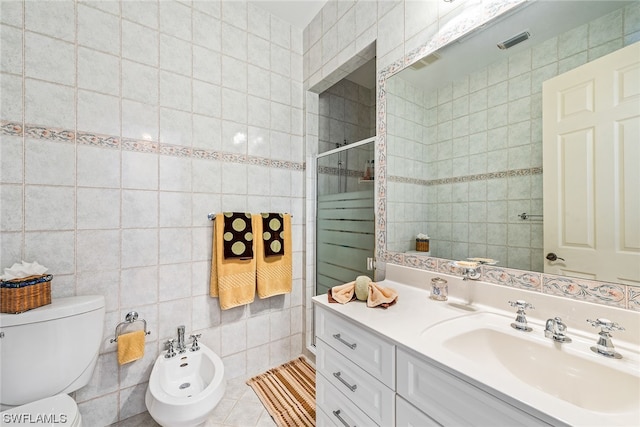 bathroom with toilet, a bidet, vanity, tile walls, and tile flooring