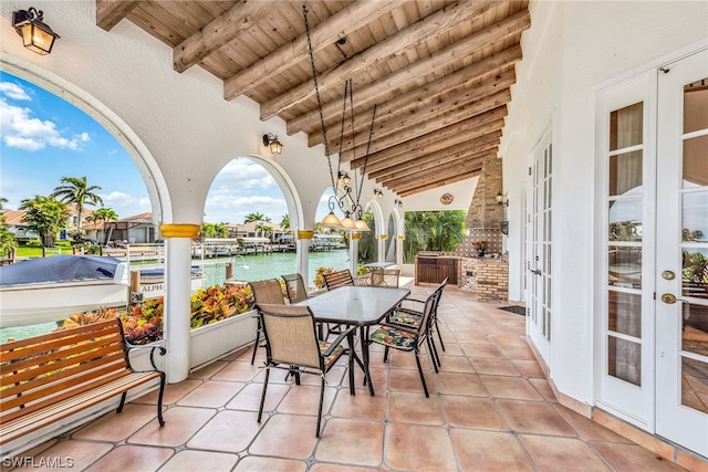 view of patio featuring a water view, french doors, and exterior kitchen