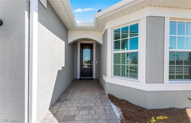 doorway to property featuring stucco siding