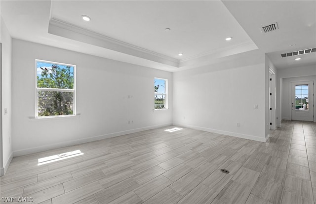 unfurnished room featuring crown molding and a tray ceiling