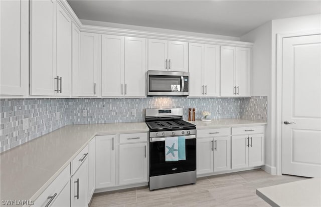 kitchen featuring white cabinetry, stainless steel appliances, and backsplash