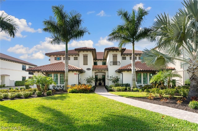 mediterranean / spanish home featuring a front lawn