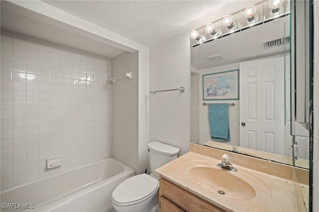 full bathroom featuring tiled shower / bath combo, vanity, a textured ceiling, and toilet