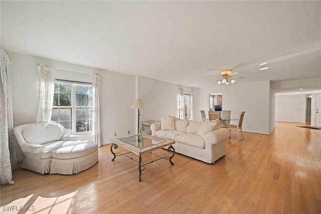 living room featuring light hardwood / wood-style flooring and ceiling fan