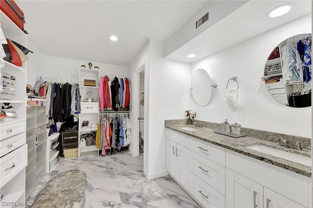 bathroom featuring a spacious closet, visible vents, marble finish floor, and a sink