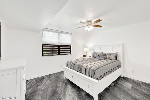 bedroom with dark wood finished floors, a ceiling fan, and baseboards