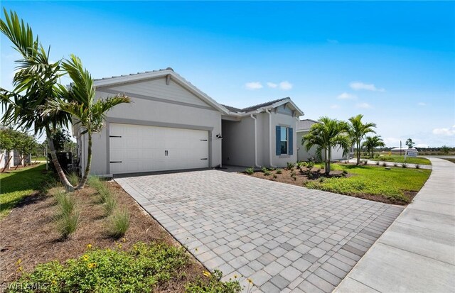 single story home featuring a garage and a front lawn