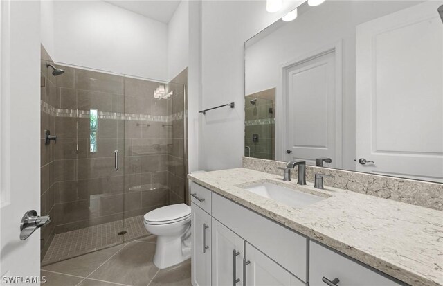 bathroom featuring tile patterned floors, vanity, toilet, and walk in shower