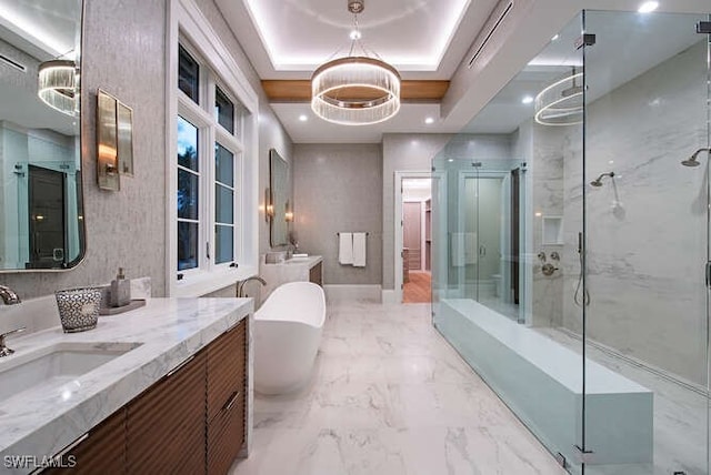 bathroom featuring a tray ceiling, vanity, a chandelier, and shower with separate bathtub