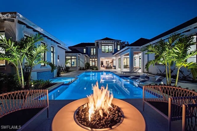 view of swimming pool featuring a patio area, an in ground hot tub, and an outdoor fire pit