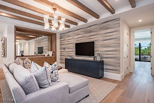 living room with a chandelier, beam ceiling, and light hardwood / wood-style floors