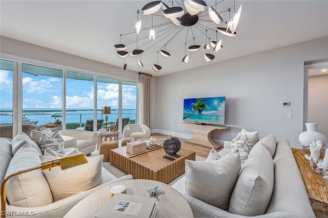 living room with an inviting chandelier, a water view, and hardwood / wood-style floors