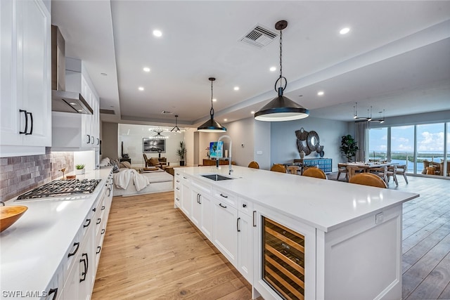 kitchen with white cabinets, backsplash, decorative light fixtures, and sink