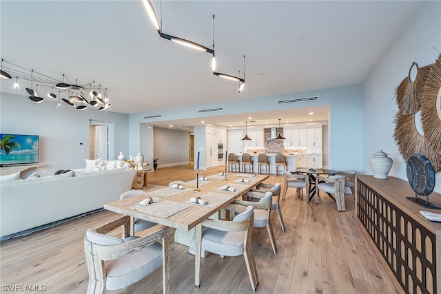 dining space featuring light hardwood / wood-style flooring and rail lighting