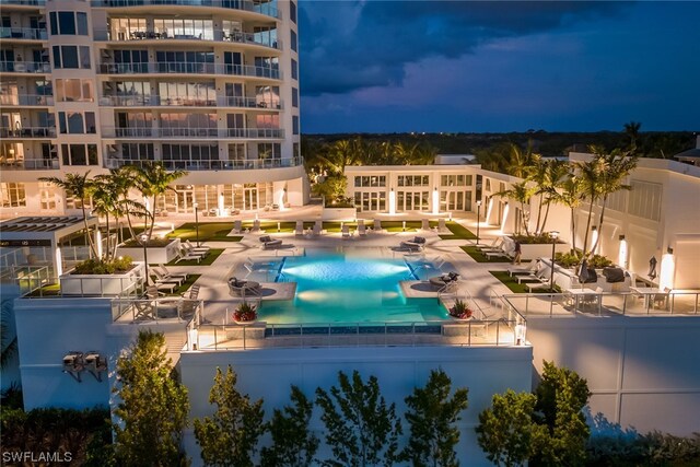 pool at night featuring a patio