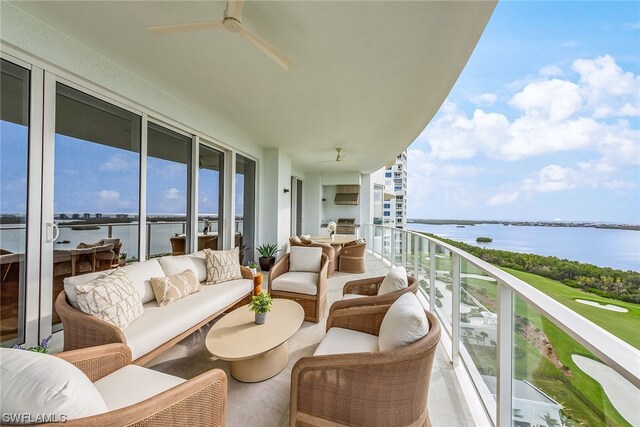 balcony featuring ceiling fan, a water view, and an outdoor living space