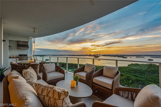 balcony at dusk featuring an outdoor hangout area and a water view