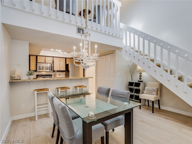 dining space featuring an inviting chandelier and light hardwood / wood-style floors