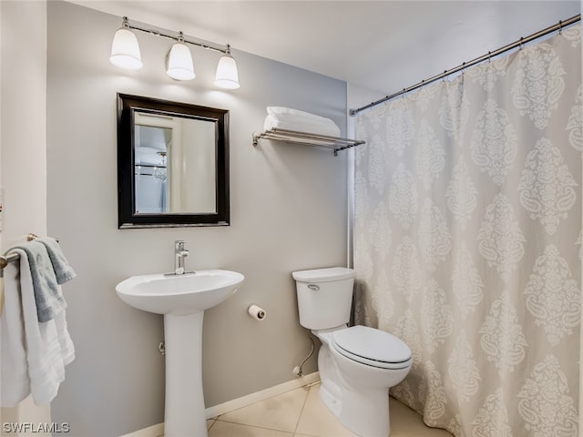 bathroom featuring sink, tile flooring, and toilet