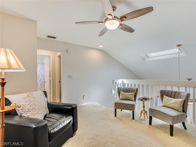 sitting room featuring lofted ceiling with skylight, light carpet, and ceiling fan