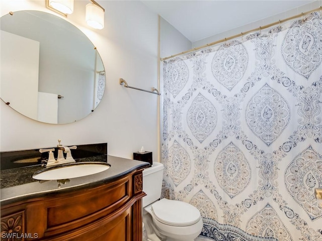 bathroom featuring vanity, a shower with curtain, and toilet