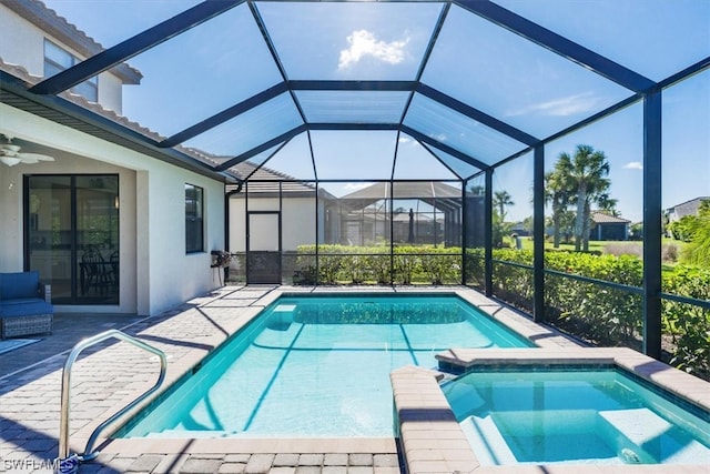 view of swimming pool featuring ceiling fan, an in ground hot tub, glass enclosure, and a patio