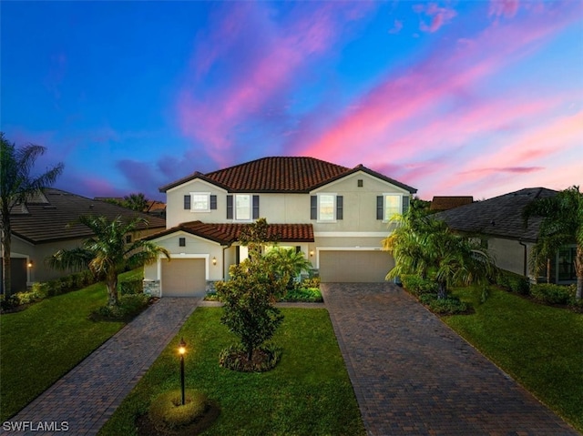 mediterranean / spanish-style home with a lawn and a garage