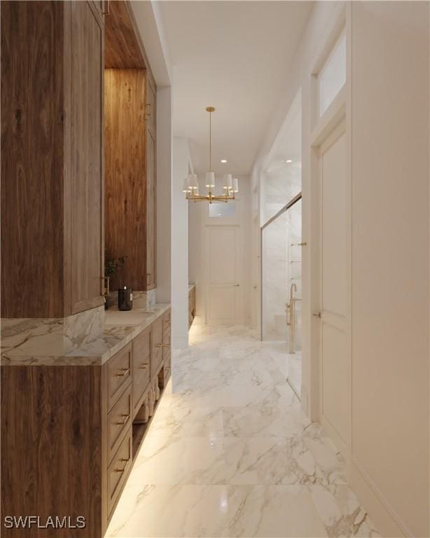 bathroom featuring a stall shower, marble finish floor, vanity, and an inviting chandelier