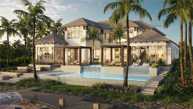 rear view of house featuring a balcony, a patio area, an outdoor pool, and stucco siding