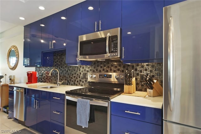 kitchen featuring blue cabinets, sink, stainless steel appliances, light tile floors, and tasteful backsplash