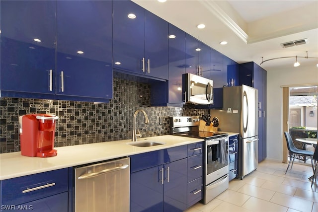 kitchen with backsplash, blue cabinets, sink, stainless steel appliances, and light tile floors