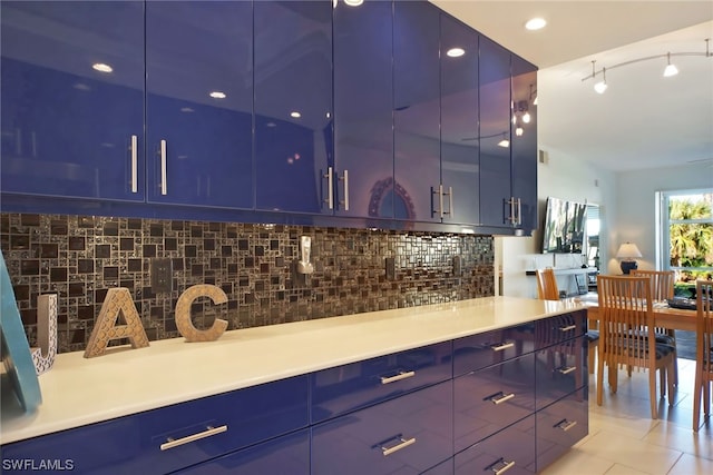 kitchen with light tile flooring, backsplash, and blue cabinets