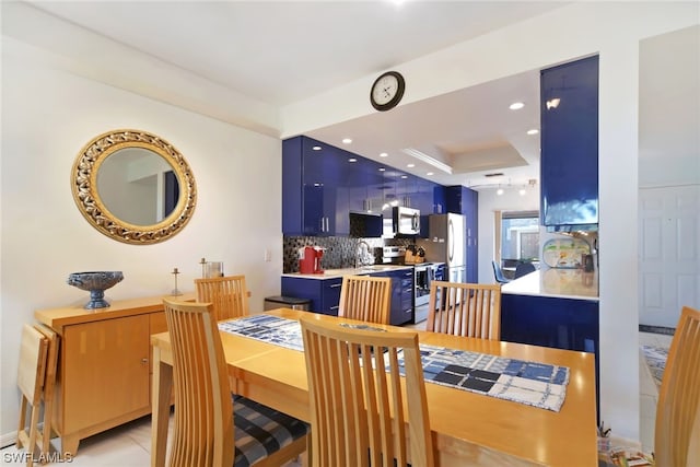 tiled dining room with a tray ceiling and sink