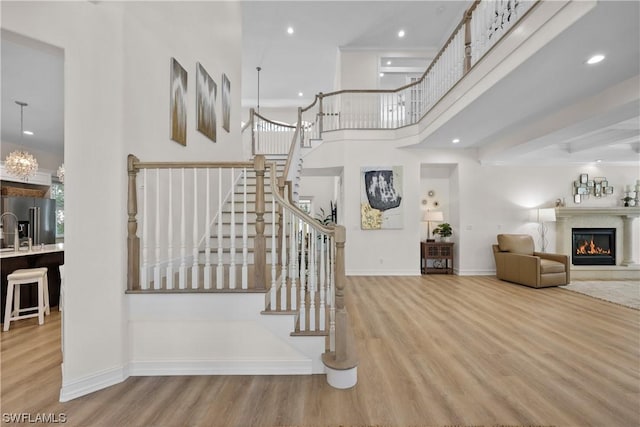 staircase with hardwood / wood-style flooring and a high ceiling